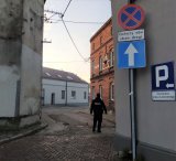 Na zdjęciu fragment ulicy Chopina w Woźnikach i idący ta ulicą policjant w mundurze.