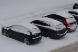 Na zdjęciu widoczne zaśnieżone pojazdy na parkingu.