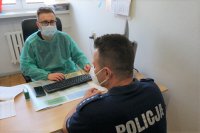 Na zdjęciu policjant w rozmowie z lekarzem przed szczepieniem.