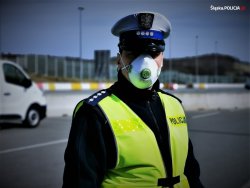 Na zdjęciu policjant w maseczce ochronnej.