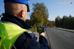 Na zdjęciu policjant w czasie kontroli prędkości na drodze.