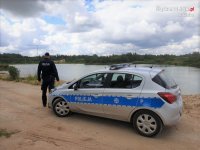 Na zdjęciu policjant kontrolujący zbiornik wodny.