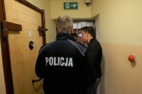 Na zdjęciu policjant wyprowadza z aresztu zatrzymanego sprawcę kradzieży.