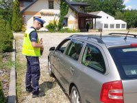 Na zdjęciu policjant w czasie kontroli pojazdu.