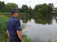 Na zdjęciu policjant w trakcie kontroli zbiornika wodnego.