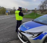 Na zdjęciu policjant mierzący prędkość na drodze.