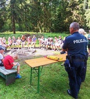 Zdjęcia przedstawiają policjantów omawiających z dziećmi temat bezpieczeństwa nad wodami.