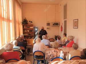 Na zdjęciu policjantka w mundurze w trakcie prelekcji dla Seniorów w lublinieckim Klubie Seniora.