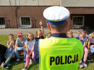 Na zdjęciu policjant w kamizelce odblaskowej w trakcie spotkania z uczniami w Lubecku.