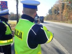 Na zdjęciu policjanci mierzący prędkość pojazdów na drodze.