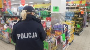 Na zdjęciu policjantka kontroluje sprzedaż fajerwerków w sklepie.