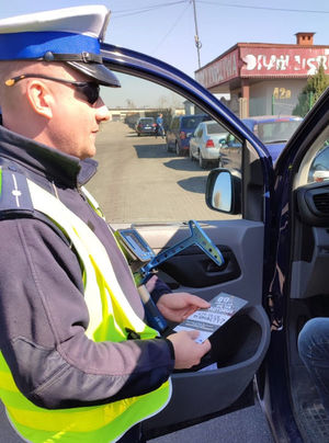 Na zdjęciu policjant w trakcie kontroli rozmawia z zatrzymanym kierowcą.