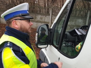 Na zdjęciu policjant rozmawia z kierowcą busa.