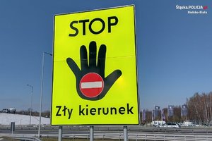 Na zdjęciu znak drogowy mówiący o złym kierunku jazdy, tablica z widoczną otwartą dłonią i napis stop, zły kierunek.