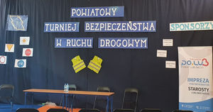 Na zdjęciu nazwa sala gimnastyczna Szkoły Podstawowej numer 3 w Lublińcu, kurtyna , a na niej napis, Powiatowy Turniej Bezpieczeństwa w Ruchu Drogowym.