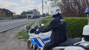 Na zdjęciu policjant na motocyklu obserwuje ruch na drodze.