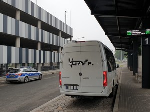 Na zdjęciu policyjny radiowóz na terenie punktu przesiadkowego w trakcie kontroli mikrobusa.