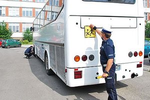 Na zdjęciu policjant w trakcie kontroli autobusu.