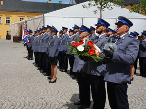 Na zdjęciu policjanci w szyku do mianowania, na pierwszym planie delegacja z kwiatami.