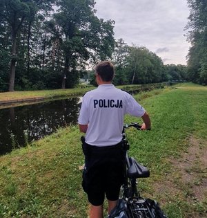 Na zdjęciu policjant kontrolujący zbiornik wodny.