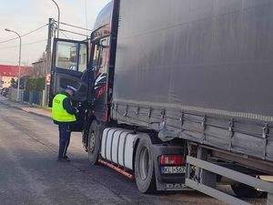 Na zdjęciu policjant kontrolujący samochód ciężarowy.