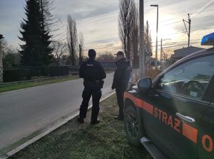 Na zdjęciu widoczni funkcjonariusze policji oraz Służby Ochrony kolei, w tle przejazd kolejowy oraz samochód Służb Ochrony Kolei.