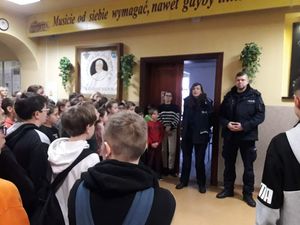 Na zdjęciu widoczni policjant i policjantka udzielający prelekcji w jednej z lublinieckich szkół. Na zdjęciu widoczna młodzież szkolna zebrana w sali.