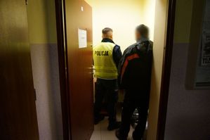 Na zdjęciu policjant badający mężczyznę urządzeniem służącym do badania trzeźwości.