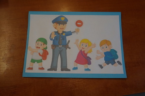Na zdjęciu widoczny obrazek namalowany przez dzieci na którym widoczny jest policjant i troje dzieci.