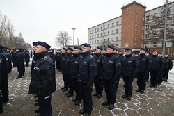 Na zdjęciu widoczni nowo przyjęci policjanci stojący na placu apelowym podczas trwania uroczystości ślubowania.