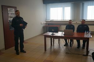 Na zdjęciu widoczny Komendant Komendy Powiatowej Policji w Lublińcu, przy stole siedzą zastępca Komendanta Wojewódzkiego oraz Komendant Powiatowy Policji w Lublińcu.