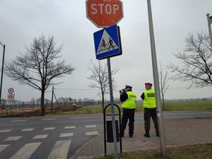 Na zdjęciu widoczny policjant z funkcjonariuszem Żandarmerii Wojskowej sojący przy drodze i mierzący prędkość.