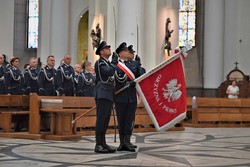 na zdjęciu widoczny jest poczet sztandarowy , trzech mundurowanych policjantów