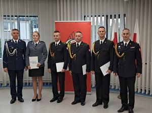 na zdjęciu widoczni są umundurowani strażacy oraz policjantka w mundurze galowy jak również komendant policji w mundurze galowym