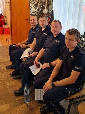 na zdjęciu widocznych jest czterech umundurowanych policjantów siedzących na krzesłach