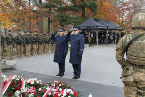 na zdjęciu widoczni są komendanci policji w Lublińcu niosący wieniec pod pomnik