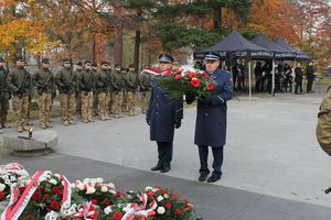 na zdjęciu widoczni są komendanci policji w Lublińcu niosący wieniec pod pomnik