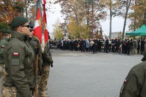 na zdjęciu widoczni są umundurowani żołnierze trzymający sztandar