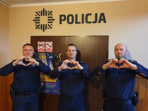 na zdjęciu widocznych jest trzech umundurowanych  policjantów wykonujących gest serca złożony z dłoni