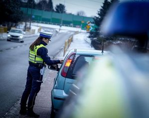 na zdjęciu widoczna jest umundurowana policjantka stojąca obok samochodu