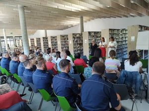 na zdjęciu widoczni są umundurowani policjanci siedzący na sali w bibliotece