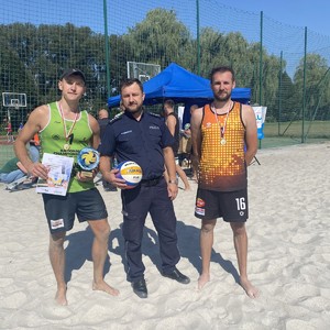 na zdjęciu widocznych jest trzech policjantów jeden w mundurze a dwóch w strojach sportowych.