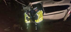 na zdjęciu widoczny jest samochód w rowie obok stoi dwóch umundurowanych policjantów