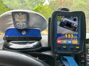 na zdjęciu widoczna jest policyjna  czapka z daszkiem, a obok miernik prędkości , na wyświetlaczu widoczna jest prędkość pojazdu