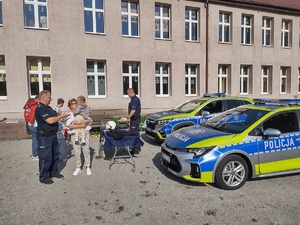 na zdjęciu widoczne są radiowozy policjant i dzieci