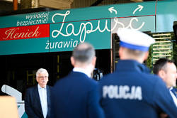 Na zdjęciu umundurowany policjant na tle hasła akcji społecznej.