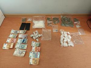 na zdjęciu widoczny jest blat stołu na którym leżą banknoty różnych nominałów oraz woreczki w których znajdują się substancje zabronione.