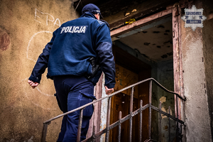 Na zdjęciu umundurowany funkcjonariusz wchodzący po schodach.