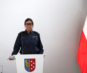 na zdjęciu widoczna jest umundurowana policjantka stojąca przy mównicy