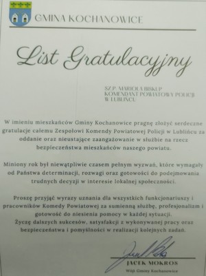 na zdjęciu widoczny jest list gratulacyjny od Wójta Gminy Kochanowice w którym skład podziękowania w imieniu mieszkańców za pełniona służbę na rzecz bezpieczeństwa mieszkańców .